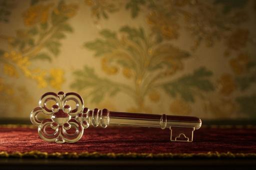 模様の上に置かれた透明なガラスの鍵 模様の上に置かれた透明なガラスの鍵の写真