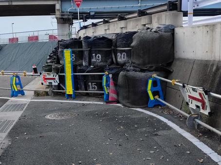 工事現場の迂回路のそばに積まれた土嚢 迂回,歩道,カラーコーンの写真素材