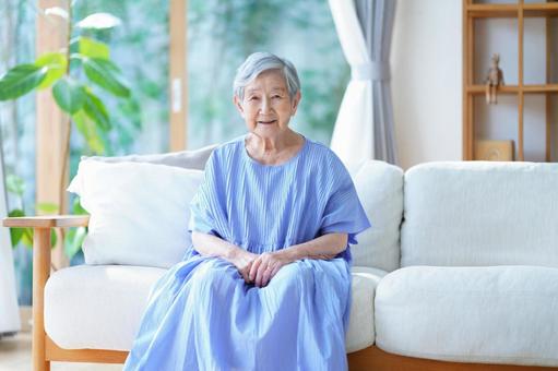 カメラ目線でソファに座るおばあちゃん 女性,ソファ,座るの写真素材