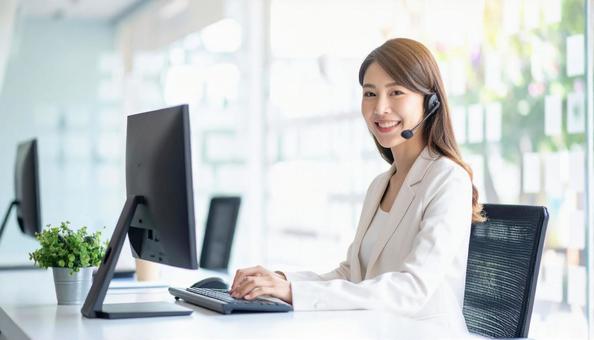 パソコンで仕事する白い服装の女性会社員 パソコンで仕事する白い服装の女性会社員の写真