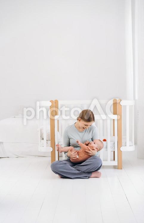 胡座で赤ちゃんを抱きあやす笑顔の母 母子,赤ちゃん,かわいいの写真素材