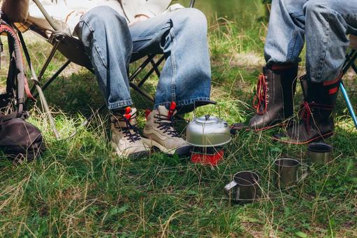 芝生の上に置かれた赤い器と人物の足元 足元,チェア,座るの写真素材
