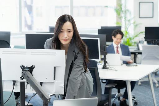 オフィスで仕事をする若いビジネスウーマン オフィスで仕事をする若いビジネスウーマンの写真