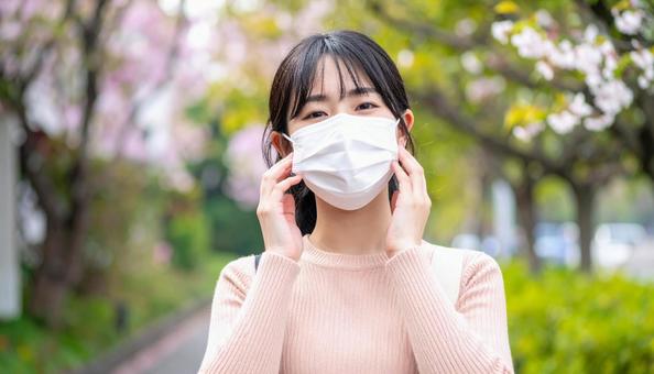 マスクをして辛そうにしている日本人女性 マスクをして辛そうにしている日本人女性の写真