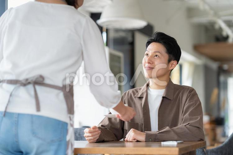 カフェの女性店員と男性のお客 カフェ,店員,スタッフの写真素材