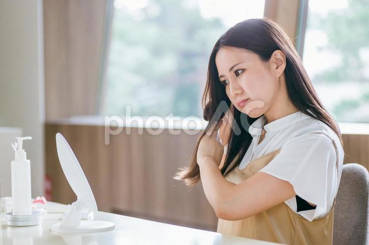 ヘアブラシで髪をとかす女性（困る） ヘアブラシ,ヘアケア,ブラッシングの写真素材