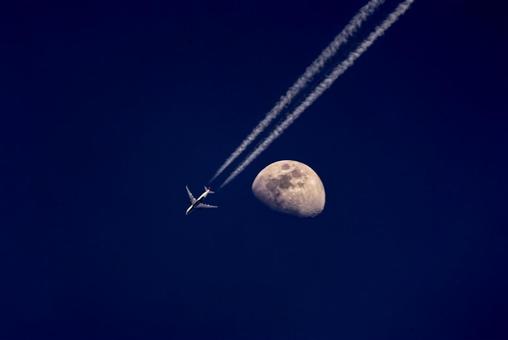 ＜素材＞夜空に浮かぶ月と近くを飛ぶ飛行機 飛行機,月,満月の写真素材