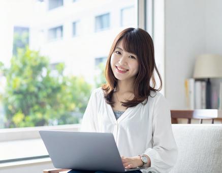 ノートパソコンを操作する若い女性 ノートパソコンを操作する若い女性の写真