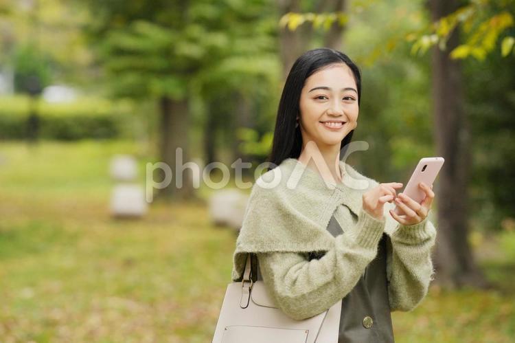 公園でスマホを使う女性 女性,日本人,１人の写真素材