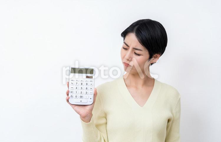 電卓を持って悩む主婦。 主婦,電卓,家計の写真素材