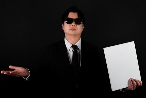 黒服の男性と白いパネル 黒服の男性と白いパネル 男性,スーツ,ネクタイの写真素材