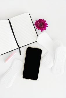 生理用ナプキンとスマートフォンとノートと花 生理,月経,生理用品の写真素材