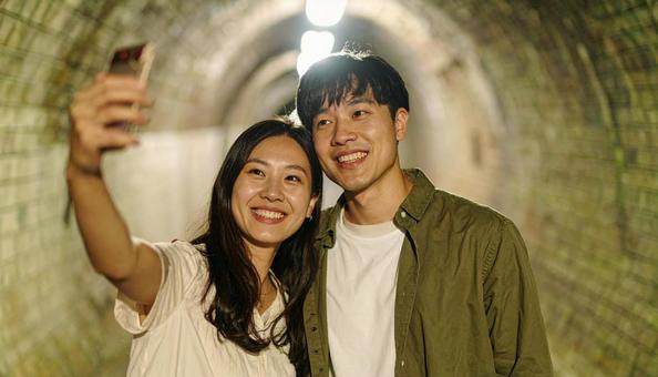 旅行先で記念撮影するカップル 旅行先で記念撮影するカップルの写真