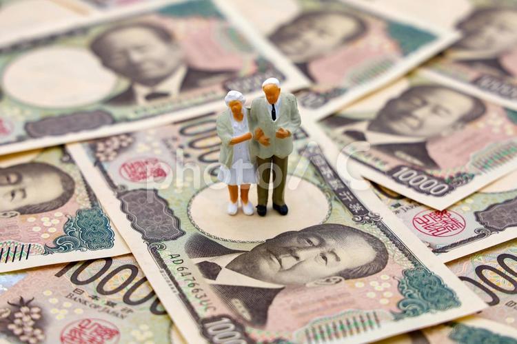 敷き詰められた１万円札と夫婦の人形 シニア,夫婦,年金受給者の写真素材