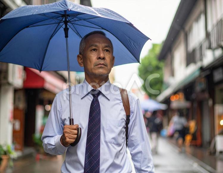 雨の商店街を歩くスーツ姿の男性 中年男性,スーツ,雨の写真素材