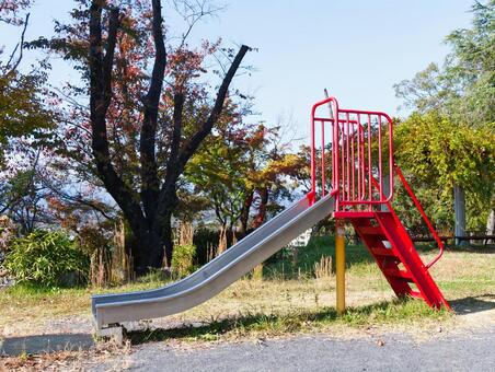 秋の公園に設置された赤いすべり台 すべり台,遊具,公園の写真素材