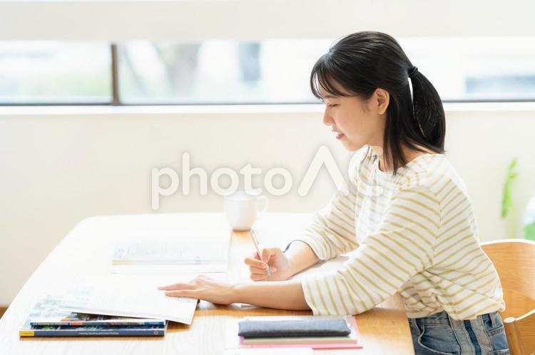 リビングで勉強をする大学生の女性 教育,勉強,女性の写真素材