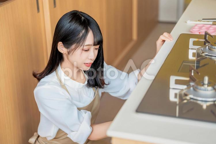 オーブンの中を見るエプロン姿の女性料理人 バレンタイン,バレンタインデー,チョコの写真素材