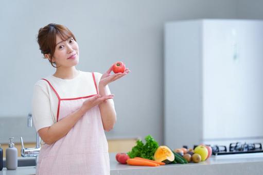 カメラ目線でトマトを持つ女性 女性,トマト,持つの写真素材