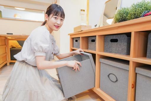 棚の片付けをする若い女性 リビング,収納,不必要の写真素材