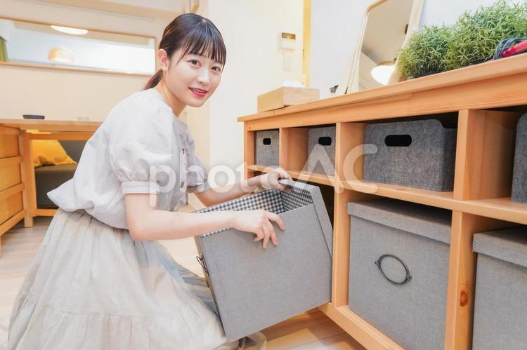 棚の片付けをする若い女性 リビング,収納,不必要の写真素材
