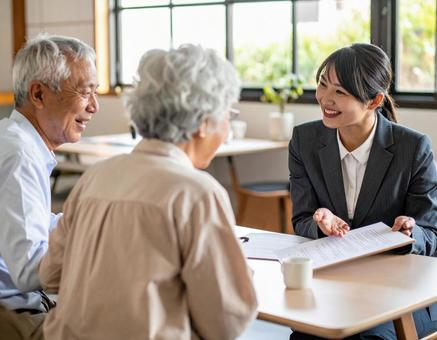 夫婦と打ち合わせするビジネスウーマン 夫婦と打ち合わせするビジネスウーマンの写真