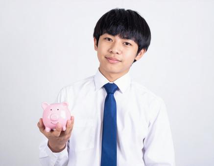 ブタの貯金箱をもつ男の子・男子生徒 ブタの貯金箱をもつ男の子・男子生徒の写真