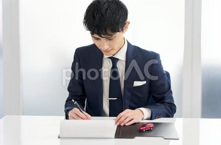 自動車の契約書にサインをするビジネスマン 男性,自動車,車の写真素材
