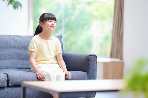 ソファに座る女の子 ソファに座る女の子の写真