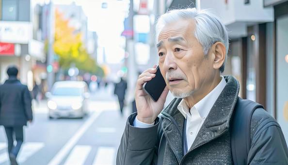 困った表情で電話する高齢者 困った表情で電話する高齢者の写真