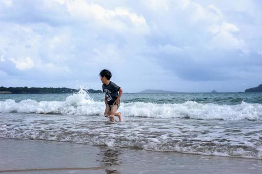 <素材>夏の海水浴場で遊ぶ男の子 <素材>夏の海水浴場で遊ぶ男の子 子供,海,空の写真素材