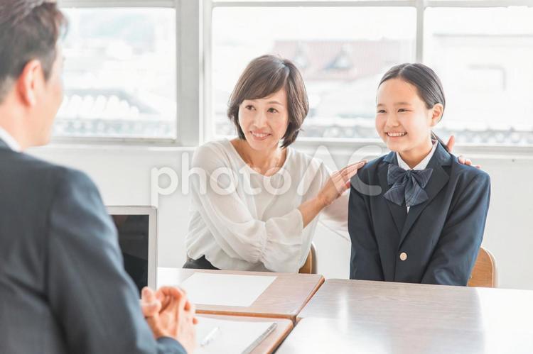 笑顔で三者面談を受ける親子と先生 学校,優等生,期待の写真素材