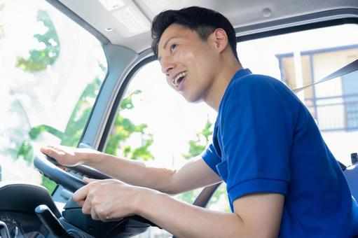 トラックを運転する男性ドライバー トラックを運転する男性ドライバー ドライバー,トラック,運転手の写真素材
