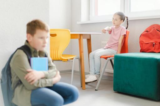 しゃがんでノートを持つ男の子を指さす女の子 男の子,女の子,子どもの写真素材