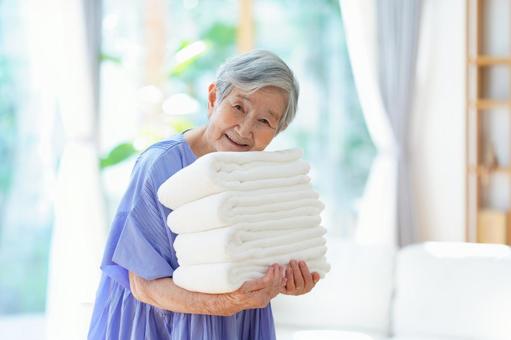 カメラ目線でタオルを持つ高齢女性 女性,タオル,持つの写真素材