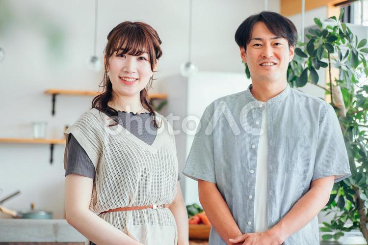 キッチンの前に立つ男女（カメラ目線） 夫婦,カップル,パートナーの写真素材