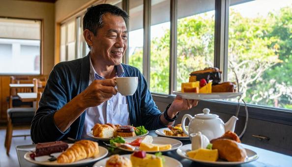 紅茶とお菓子でティータイムを楽しむ男性 紅茶とお菓子でティータイムを楽しむ男性の写真
