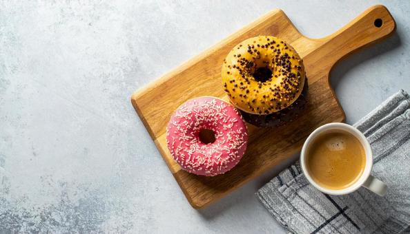 カッティングボードのドーナツとコーヒー カッティングボードのドーナツとコーヒーの写真