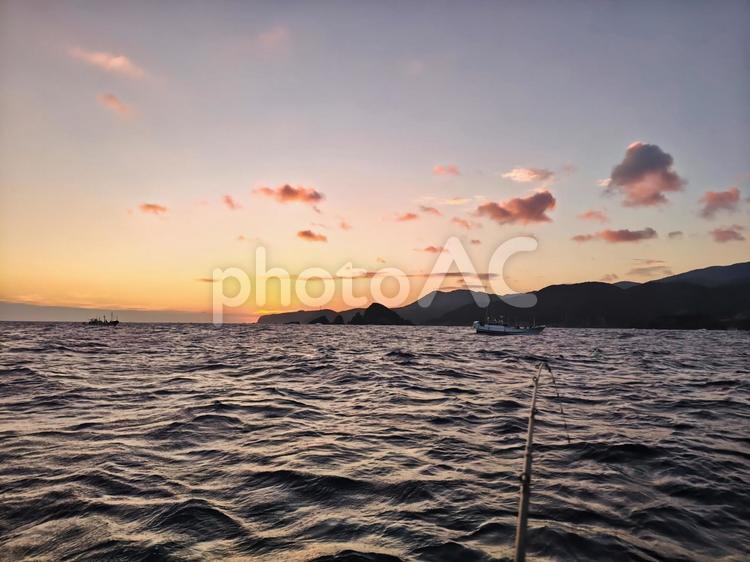 夕焼けに染まる海と釣り竿のシルエット 夕焼け,船,釣りの写真素材