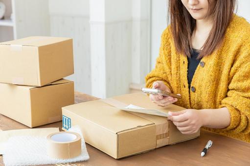 荷物の発送準備をする女性 配送,配達,段ボールの写真素材