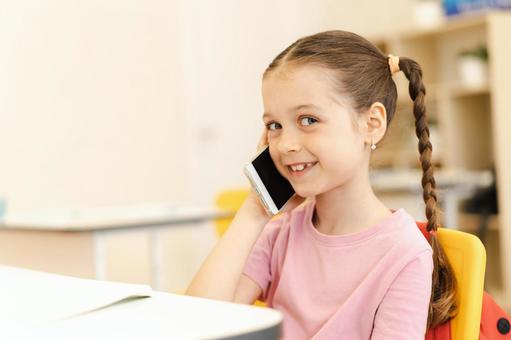 笑顔で携帯で電話する女の子 女の子,子ども,人物の写真素材