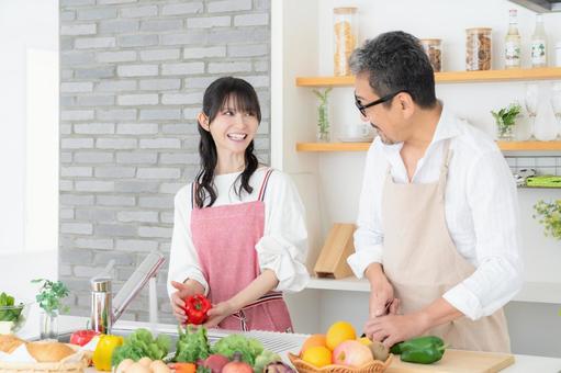 キッチンで料理を作るミドルの夫婦 キッチンで料理を作るミドルの夫婦 料理,夫婦,家族の写真素材