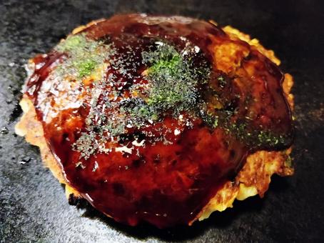 鉄板にのった熱々のお好み焼き 鉄板にのった熱々のお好み焼き お好み焼き,ソース,青のりの写真素材
