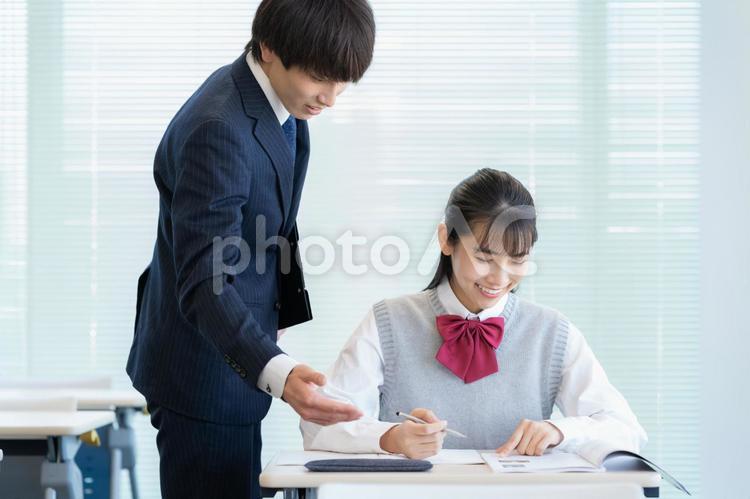 学校で勉強を教える先生と女子高生 塾,教育,勉強の写真素材