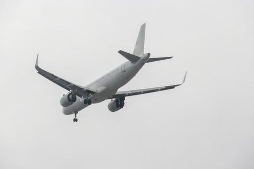 暗い雲を背景に飛ぶ飛行機 飛行機,航空機,旅客機の写真素材