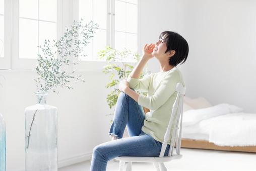 椅子に膝立ちで座る若い女性 椅子に膝立ちで座る若い女性 女性,座る,日本人の写真素材