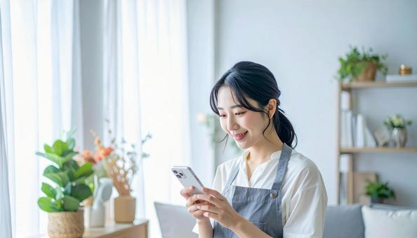 スマホでポイ活する笑顔の女性 スマホでポイ活する笑顔の女性の写真