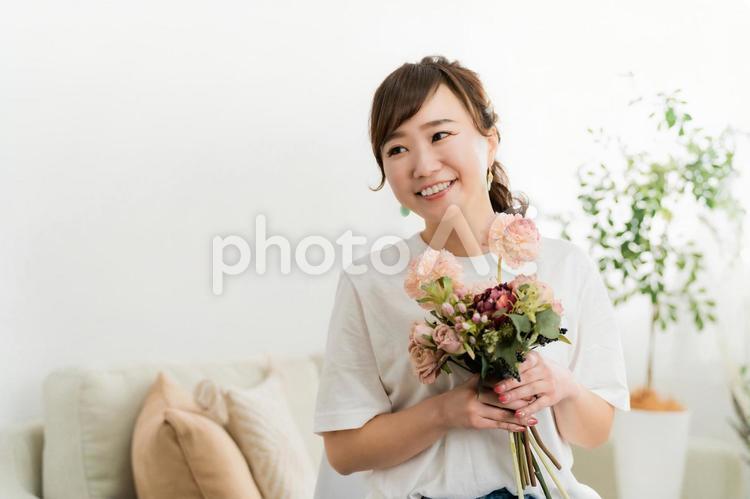 家のソファで花束を持つ日本人女性 母の日,花束,花の写真素材