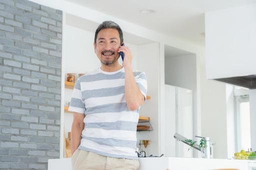 キッチンでスマホを使うミドルの男性 男性,スマホ,ミドルの写真素材