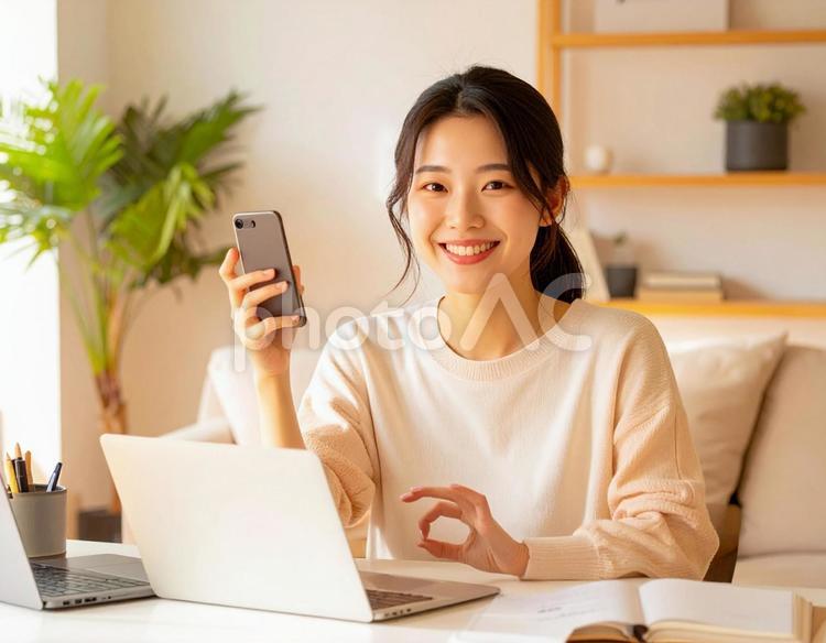 家計がうまくいきスマホ片手に微笑む女性 パソコン,家計簿,節約の写真素材